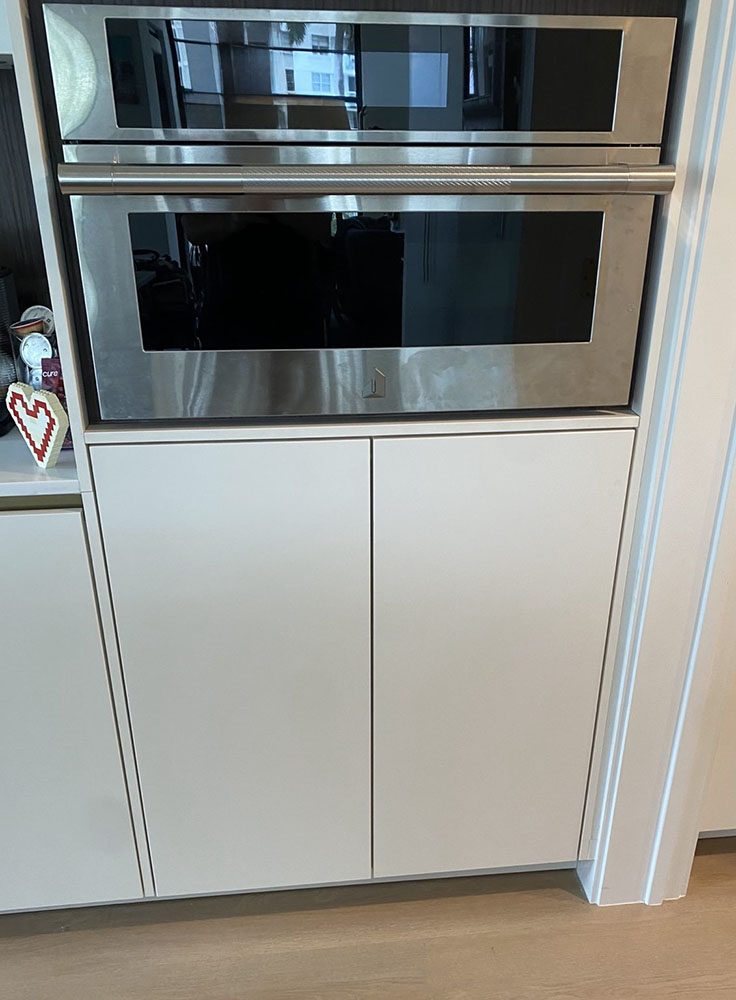 Built-in oven installed into white custom kitchen cabinetry