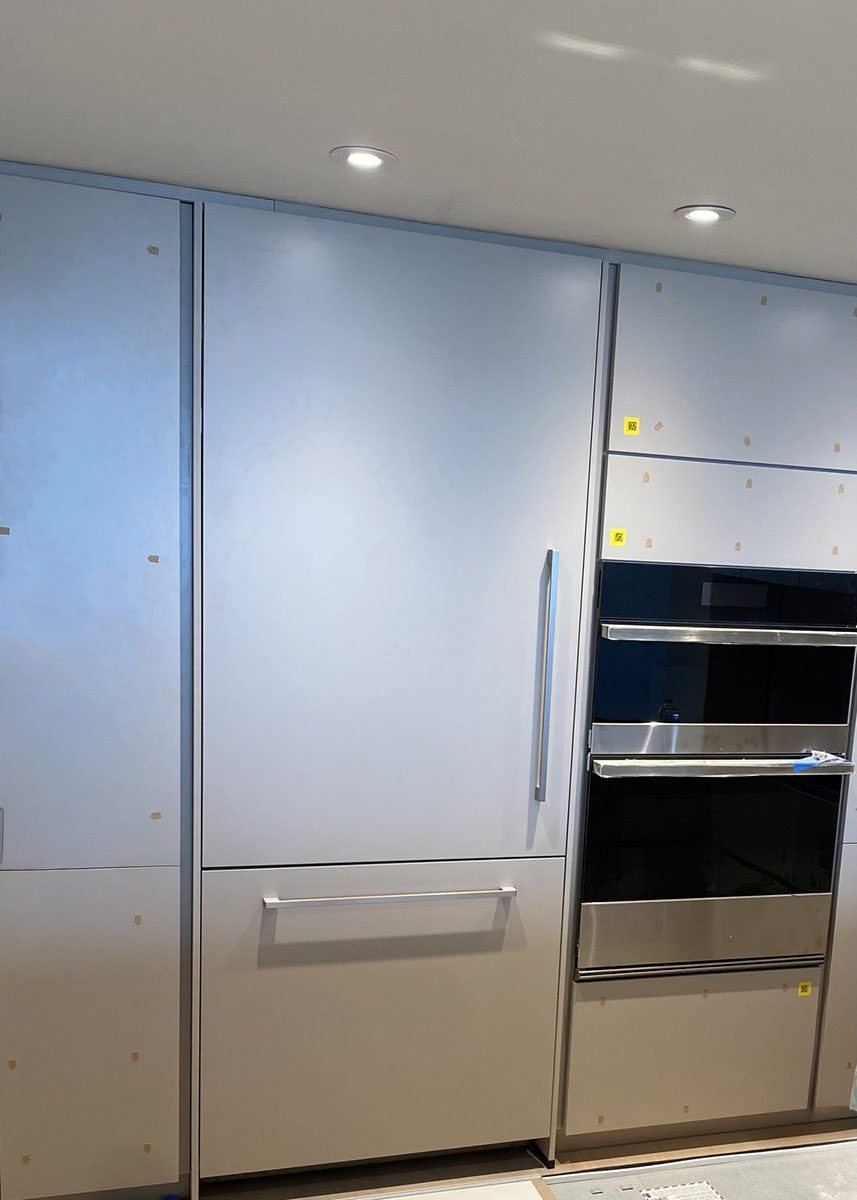 Luxury built-in refrigerator installation with oven tower nearby