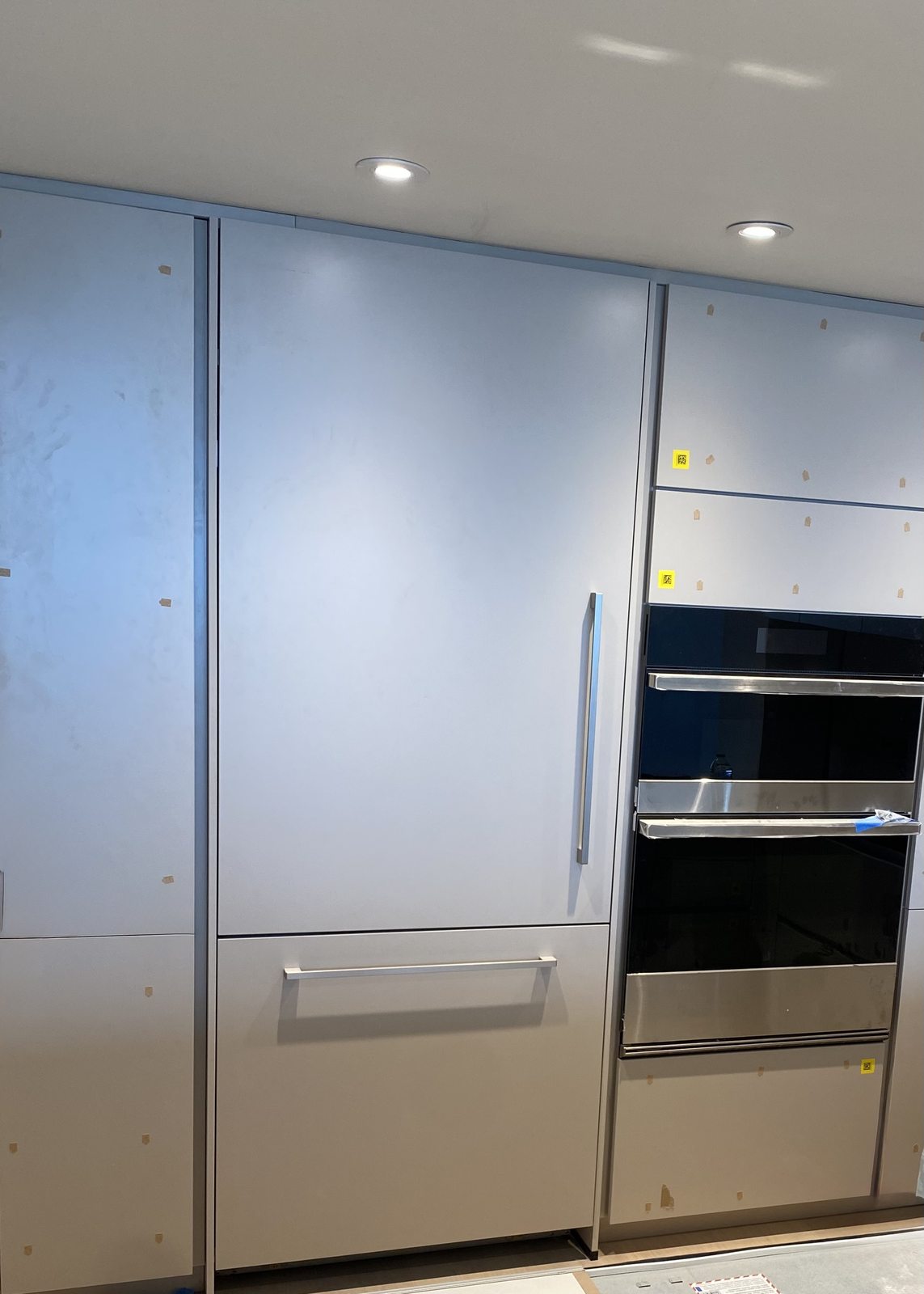 Luxury built-in refrigerator installation with oven tower nearby