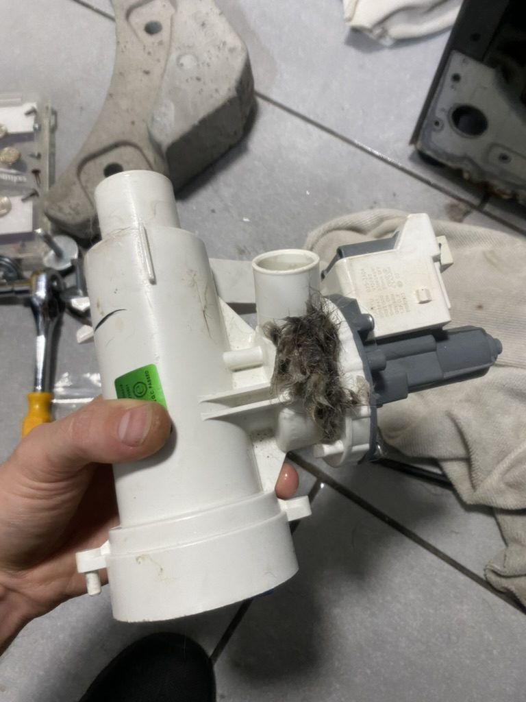 Clogged drain pump removed during washer repair